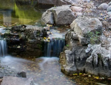 Pondless waterfalls flowing over rocks in a landscaped area
